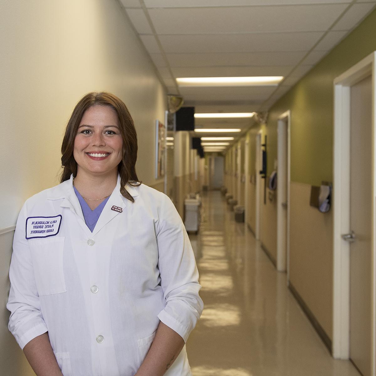凯拉·麦克劳克林身穿白衣在医院走廊微笑的照片