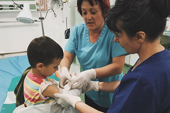 Photo of two nurses helping a child